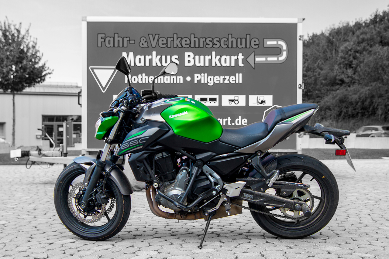 Motorrad in silber, grün, schwaz. Hintergrund in schwarz weiß