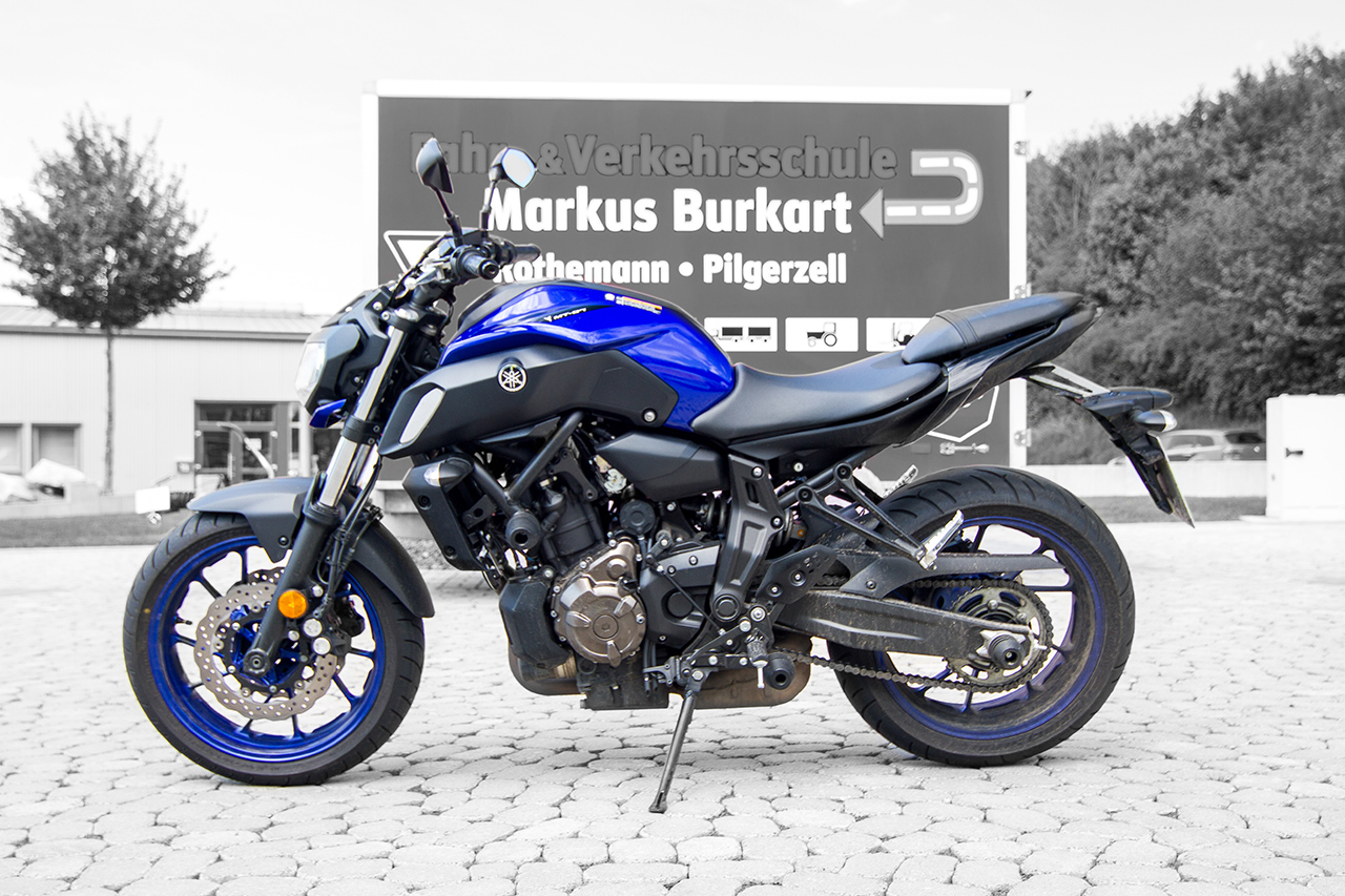 Motorrad in blau, schwaz. Hintergrund in schwarz weiß
